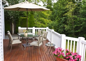 Outdoor patio setup on cedar wood deck with trees in background