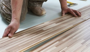 Close Up Of Construction Worker Installing Floor Panels