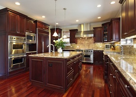 Kitchen in luxury home with cherry wood cabinetry matching the hardwood flooring
